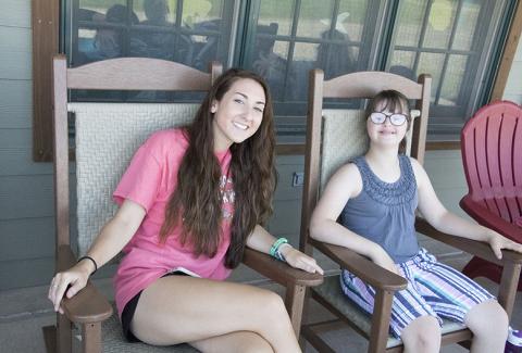 Camp counselor and camper relax on patio