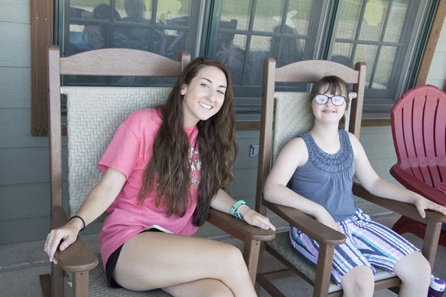 Camp counselor and camper relax on patio